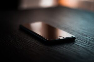 Fotografii alb-negru vechi așezate pe o masă, lângă un telefon