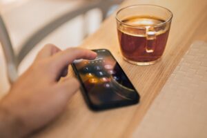 Telefon cu harta afișată, fixat pe bordul unei mașini pe un drum de țară
