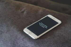 Telefon cu ecranul de blocare afișat, așezat pe o masă de lemn